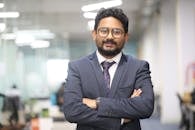 Confident man in a suit standing in a modern office, showcasing professionalism.